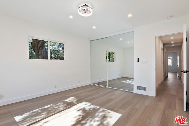 unfurnished bedroom featuring hardwood / wood-style floors and a closet