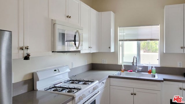 kitchen with white cabinetry, sink, and white appliances