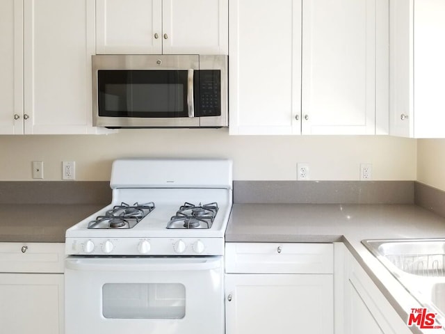 kitchen featuring white cabinetry and white range with gas stovetop