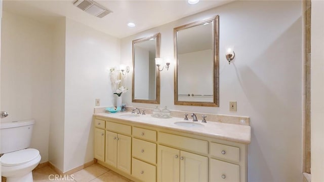 bathroom with tile patterned flooring, vanity, and toilet