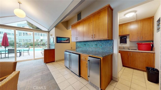 kitchen featuring light tile patterned flooring, refrigerator, vaulted ceiling, and hanging light fixtures