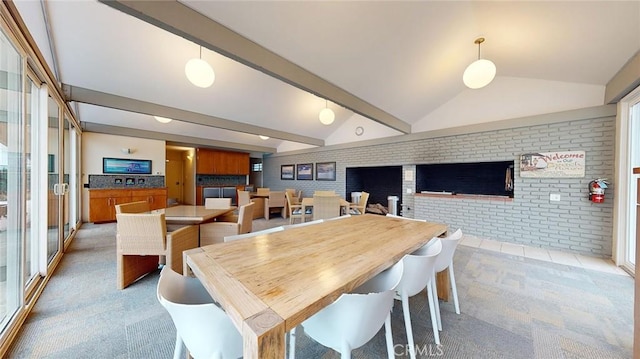 carpeted dining room with vaulted ceiling with beams, plenty of natural light, and brick wall