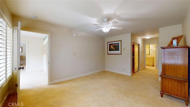 spare room featuring ceiling fan and light colored carpet