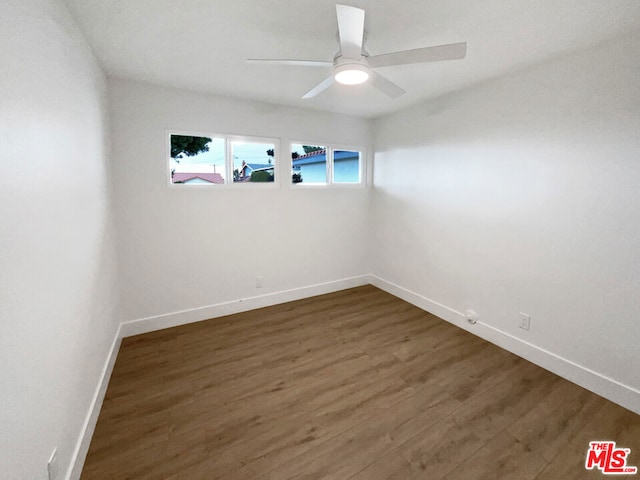 empty room with dark wood-type flooring and ceiling fan