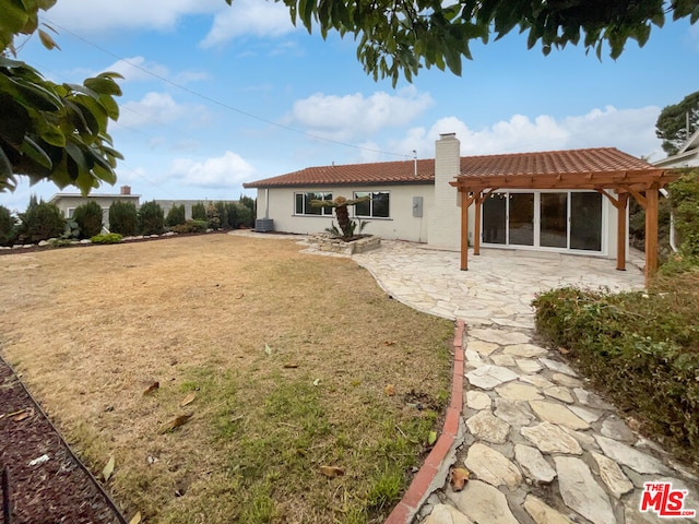 back of house featuring a yard, a patio area, and a pergola