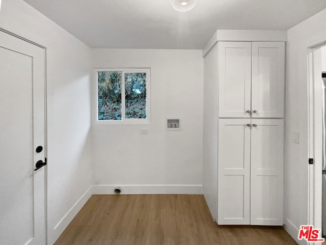 washroom featuring cabinets, hookup for a washing machine, and light wood-type flooring