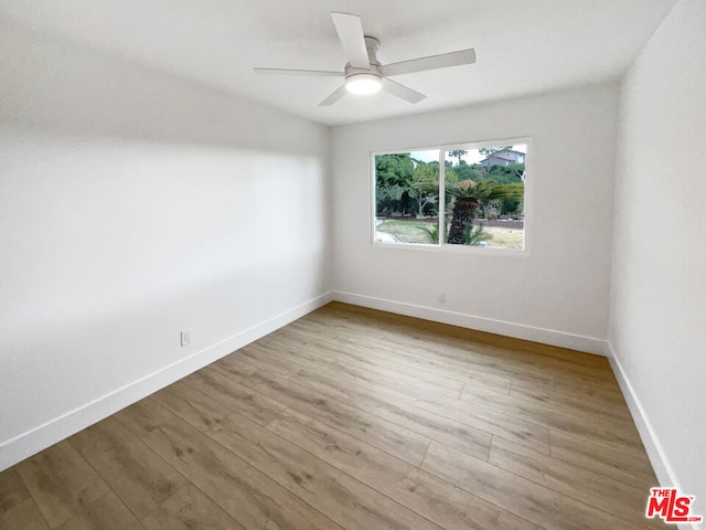 spare room with ceiling fan and light wood-type flooring