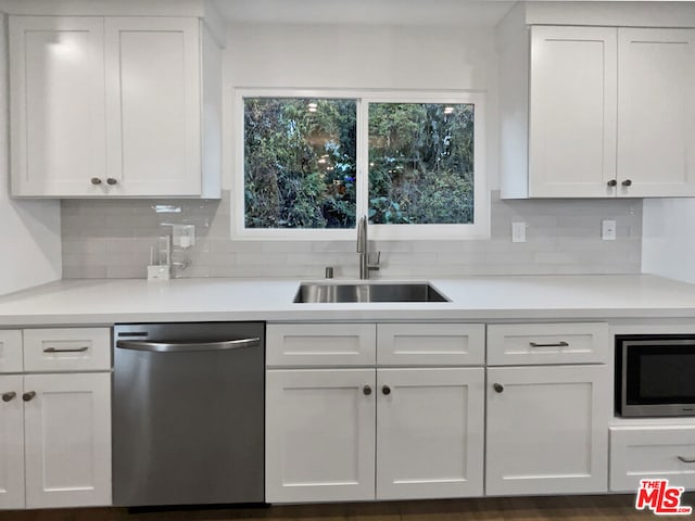 kitchen featuring a wealth of natural light, built in microwave, dishwasher, white cabinetry, and sink