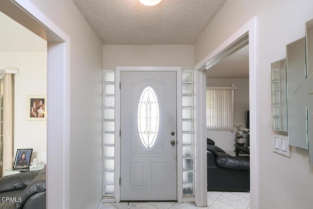 foyer featuring light tile patterned floors and a textured ceiling