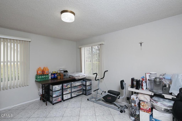 workout room with light tile patterned flooring and a textured ceiling