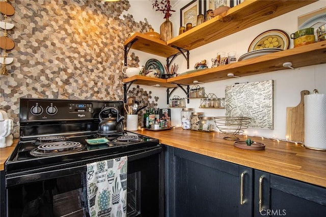 kitchen with butcher block countertops, black range with electric stovetop, and blue cabinets