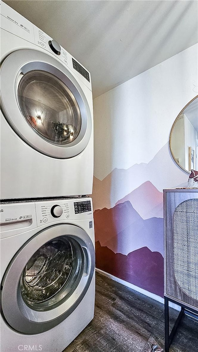 laundry area featuring stacked washer and dryer and dark hardwood / wood-style floors