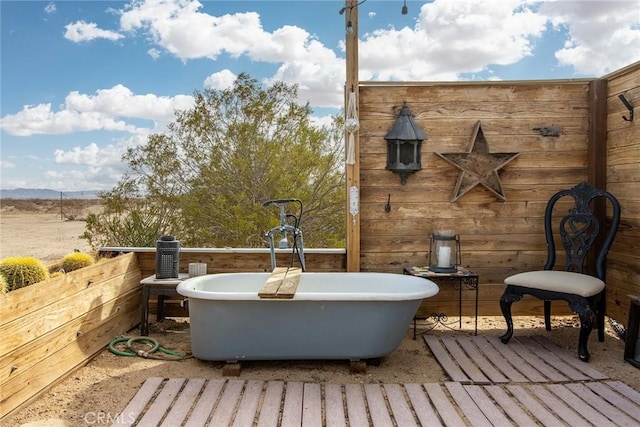 exterior space featuring wooden walls and a bath