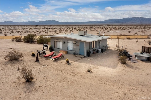 back of property featuring a mountain view and central AC