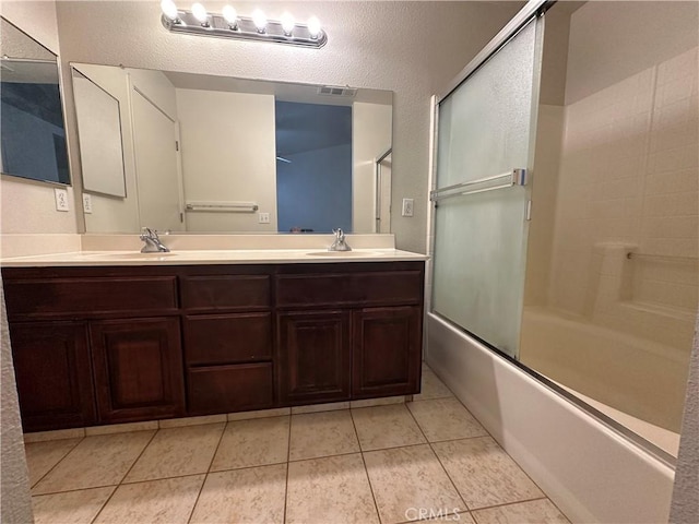 bathroom with tile patterned floors, vanity, and bath / shower combo with glass door