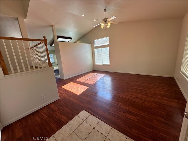 unfurnished living room with hardwood / wood-style flooring, ceiling fan, and lofted ceiling