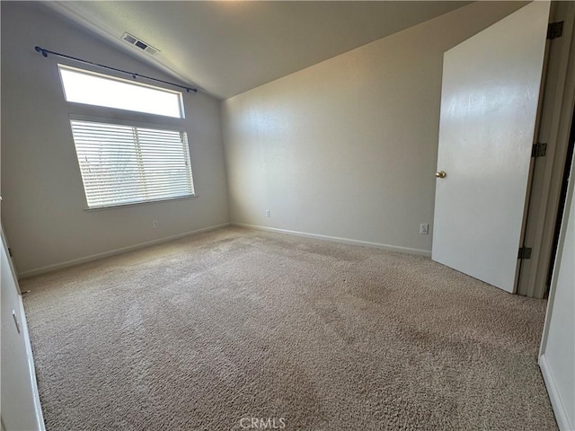 carpeted spare room featuring lofted ceiling