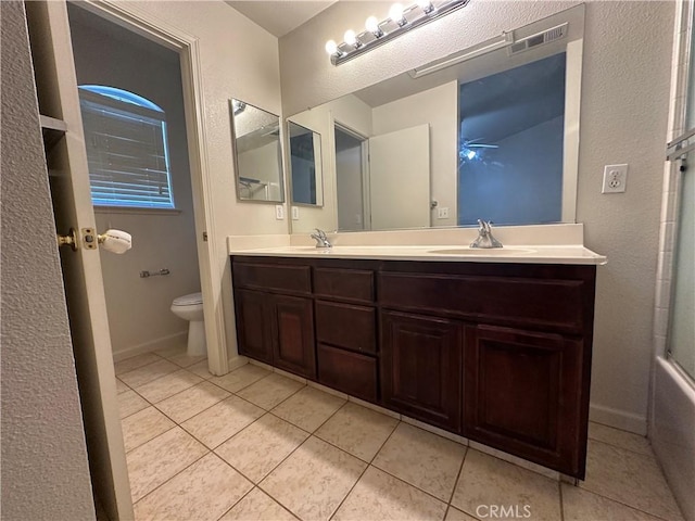 full bathroom with vanity, tile patterned floors, shower / bath combination with glass door, and toilet