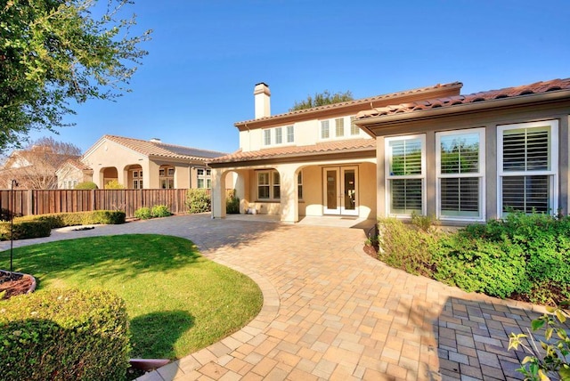 rear view of property with a patio, a yard, and french doors