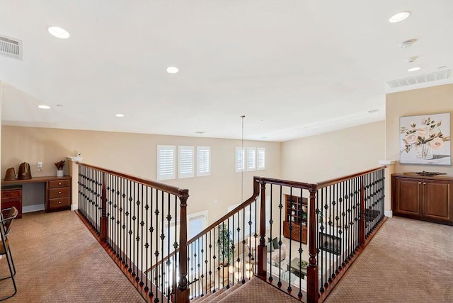 corridor featuring light colored carpet