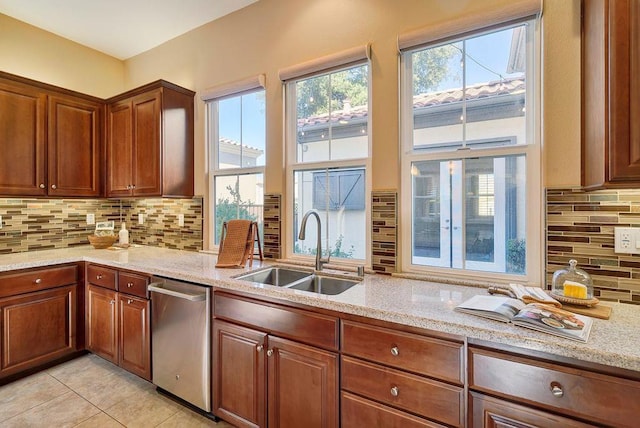 kitchen featuring sink, backsplash, light stone countertops, and dishwasher