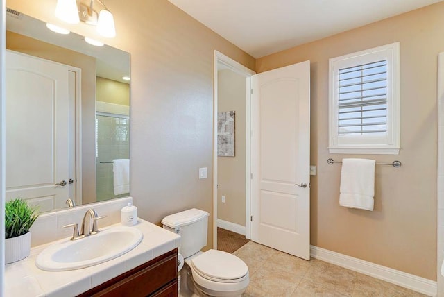 bathroom featuring tile patterned flooring, vanity, an inviting chandelier, and toilet