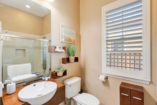 bathroom with sink, an enclosed shower, and toilet