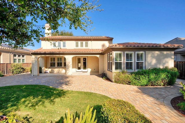 back of house featuring a patio area, french doors, and a lawn