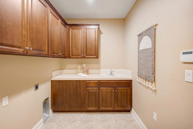 laundry area with cabinets, hookup for an electric dryer, sink, and light tile patterned floors