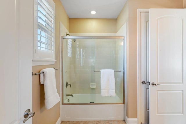 bathroom with combined bath / shower with glass door