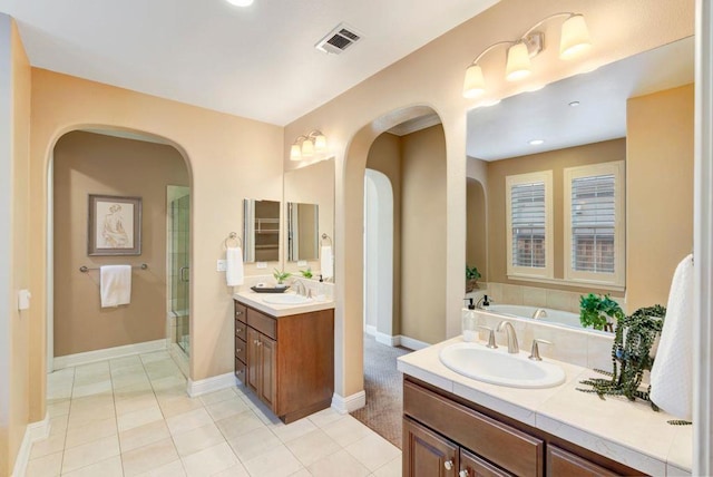 bathroom with plus walk in shower, vanity, and tile patterned floors