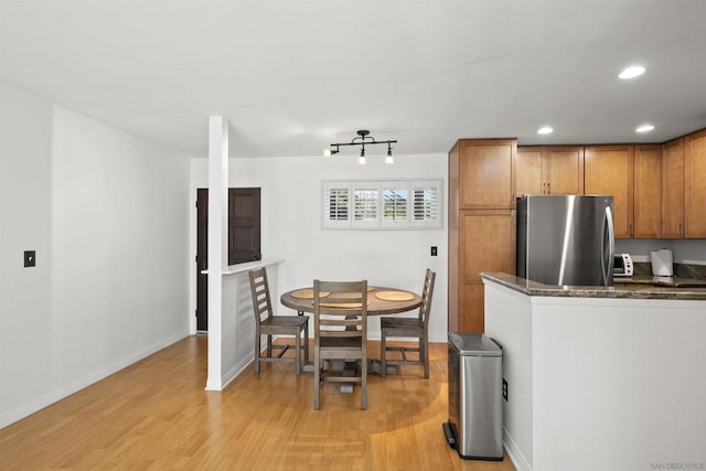 kitchen featuring stainless steel refrigerator and light hardwood / wood-style floors