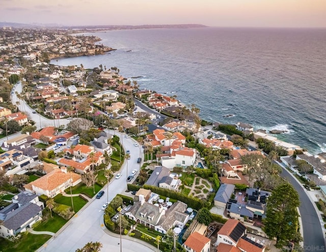 aerial view at dusk featuring a water view