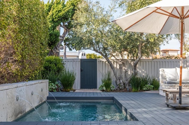 view of swimming pool with pool water feature and a wooden deck