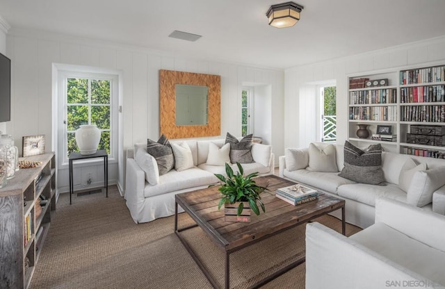 carpeted living room with ornamental molding