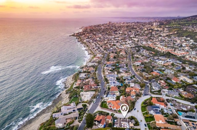 aerial view at dusk with a beach view and a water view