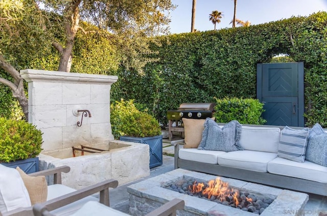 view of patio with an outdoor living space with a fire pit