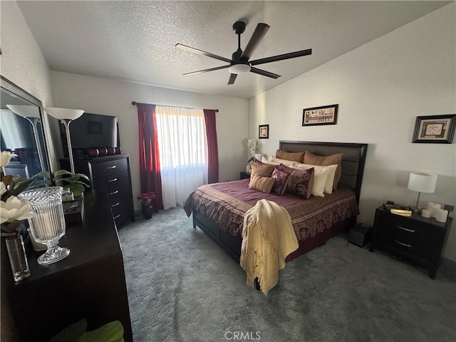 bedroom with ceiling fan, a textured ceiling, and dark colored carpet