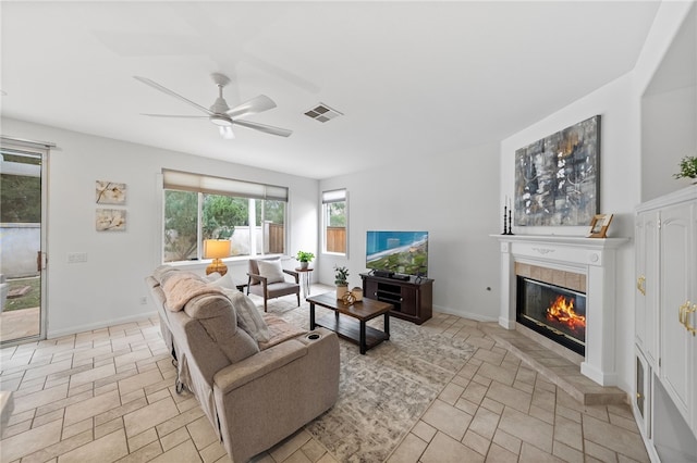 living room featuring a fireplace and ceiling fan