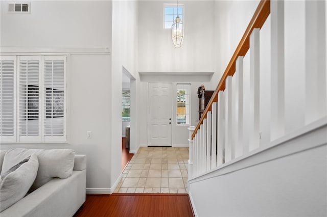 entrance foyer featuring a healthy amount of sunlight, light tile patterned floors, and a chandelier