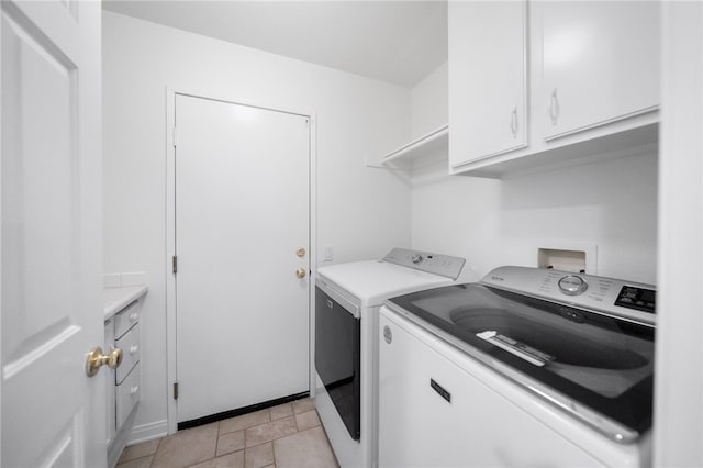 washroom featuring cabinets, light tile patterned floors, and independent washer and dryer