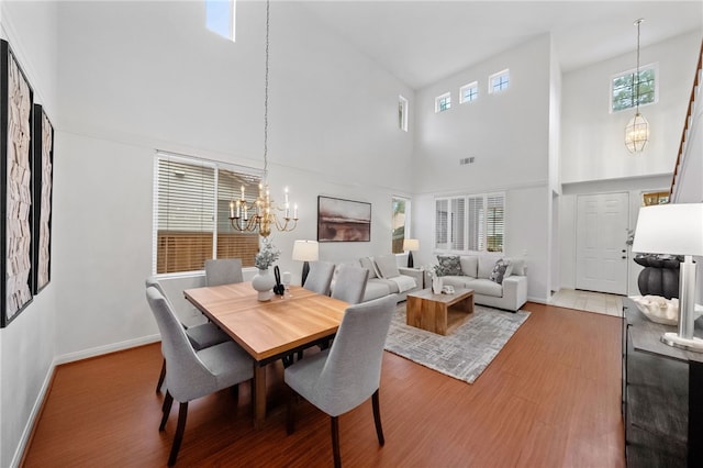 dining room featuring a high ceiling, plenty of natural light, and an inviting chandelier