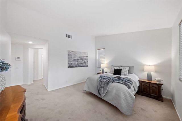 bedroom with vaulted ceiling and light colored carpet