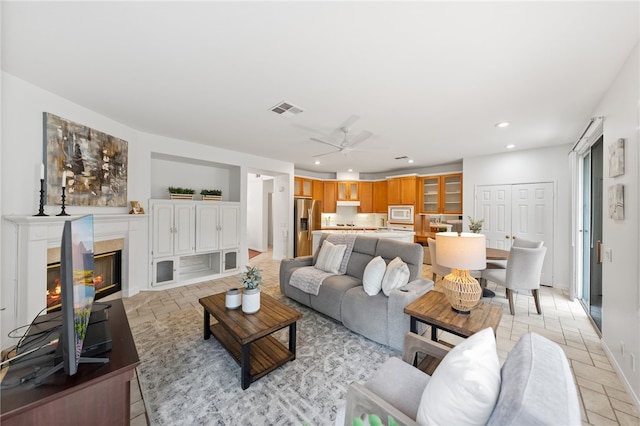 living room with ceiling fan and a wealth of natural light