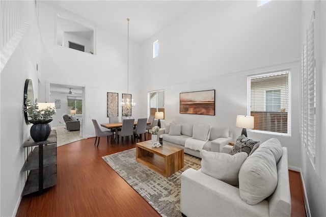 living room with a high ceiling, hardwood / wood-style floors, and a notable chandelier