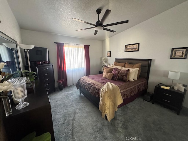 bedroom featuring ceiling fan, dark carpet, and a textured ceiling