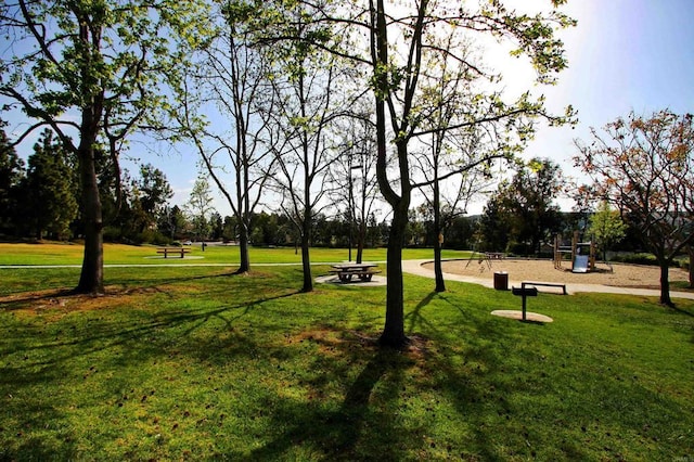 view of property's community featuring a yard and a playground