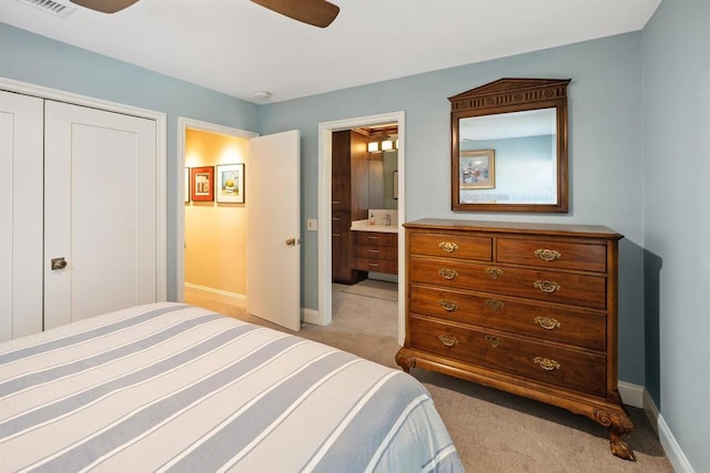 bedroom featuring ensuite bath, light colored carpet, a closet, and ceiling fan