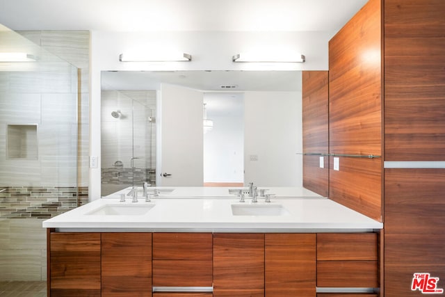 bathroom with vanity and a shower with door