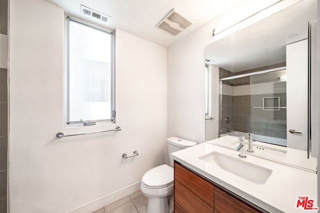 full bathroom featuring tile patterned flooring, vanity, shower / bath combination with glass door, and toilet